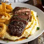 Cowboy Buttr Steak with Onion Rings on Mashed Potatoes